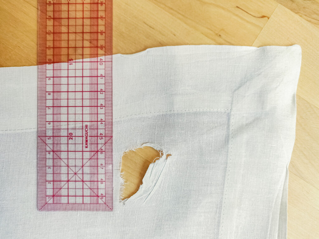Déchirure dans l'angle d'une nappe à upcycler de 140x140 cm